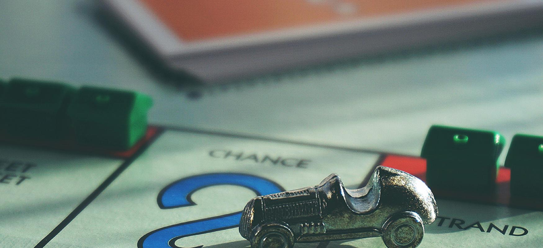 Board game with a car playing piece parked on a chance card field.