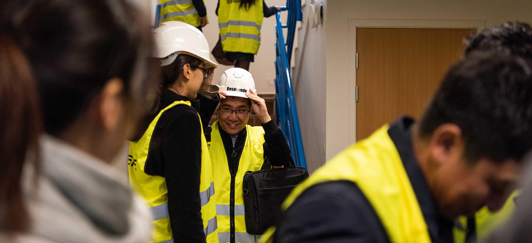 A Chinese delegation wearing yellow vests and hard hats at a sight visit in Norway.