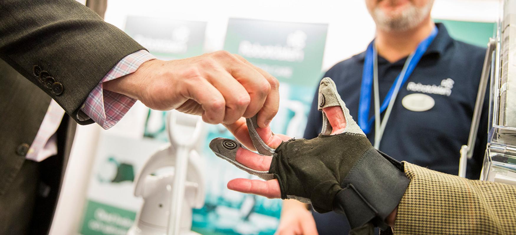 Man testing a health technology device in the form of a glove at Vitalis 2018.