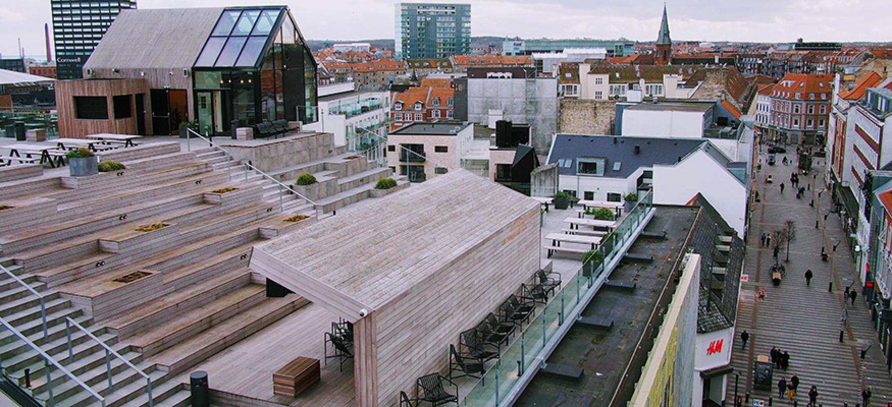 A wooden rooftop terrace and city skyline