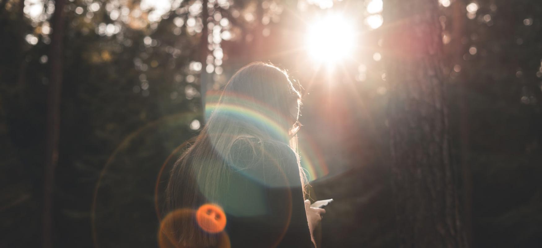 Woman in the woods with smartphone