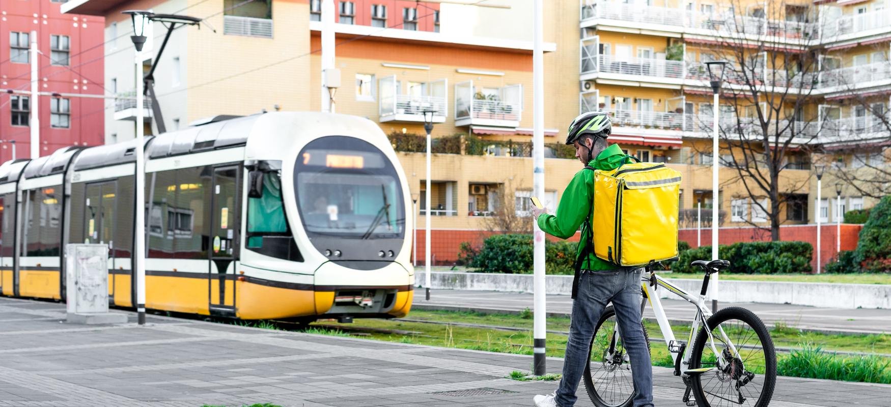 Cykelbud der står foran et tog