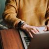 Woman sitting at a desk writing on her laptop