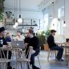 people sitting at tables in a cafe and working