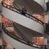 Woman standing on stairs in a library in Helsinki.