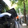 charger in an electric car, parked in the city with trees in the background