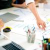 Personer der sidder ved et bord og arbejder med innovation