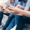 Three persons sitting on the stair playing with their mobile phones